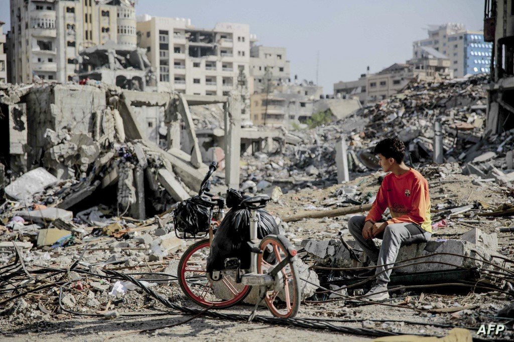 PALESTINIAN-ISRAEL-CONFLICT A Palestinian youth sits next to his bicycle amid the rubble of destroyed buildings in Gaza City on the northern Gaza strip following weeks of Israeli bombardment, as a four-day ceasefire took effect on November 24, 2023. The truce in the Israel-Hamas war began on November 24 and appeared to be holding, under a deal that will see hostages released in exchange for Palestinian prisoners. (Photo by AFP)